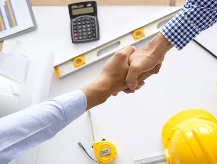 A set of hands shaking over construction site items