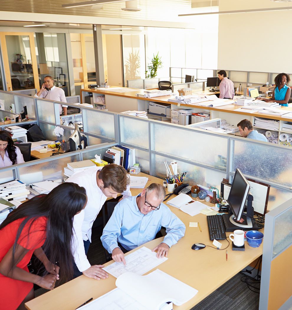 Busy office with several people working reviewing documents