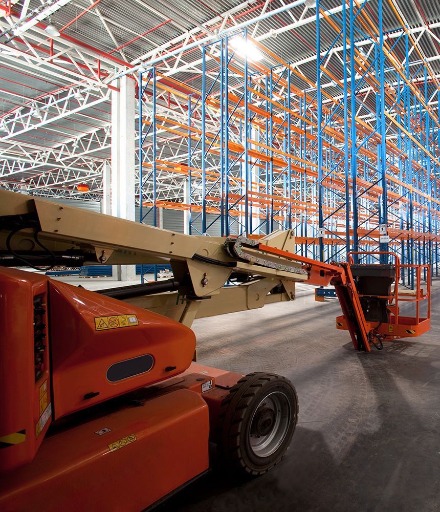 Cherry picker inside of a large empty warehouse
