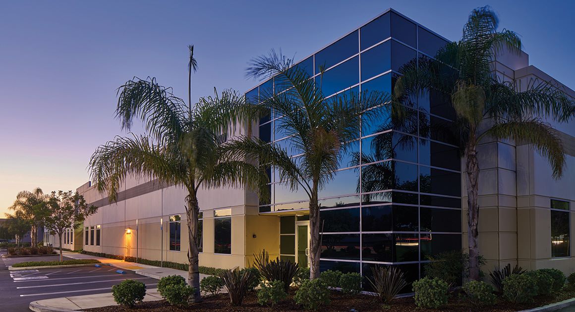 Sunset photo of an industrial building in Southern California with palm trees