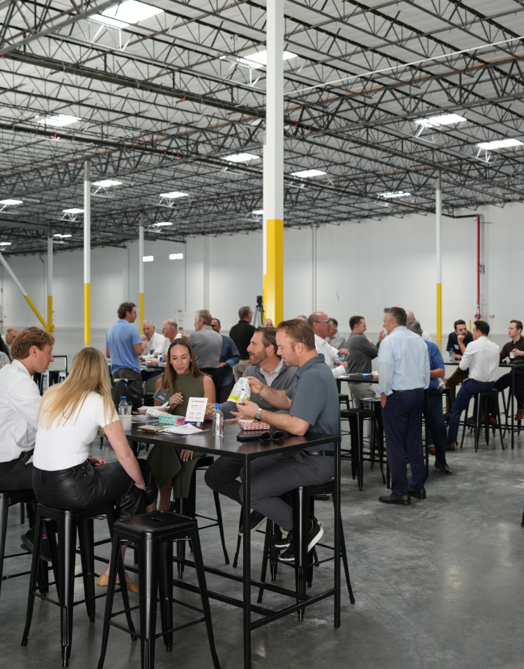 Group of Rexford employees with industrial real estate brokers inside a warehouse
