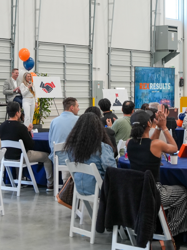 Group photo at an all hands meeting inside a Rexford warehouse