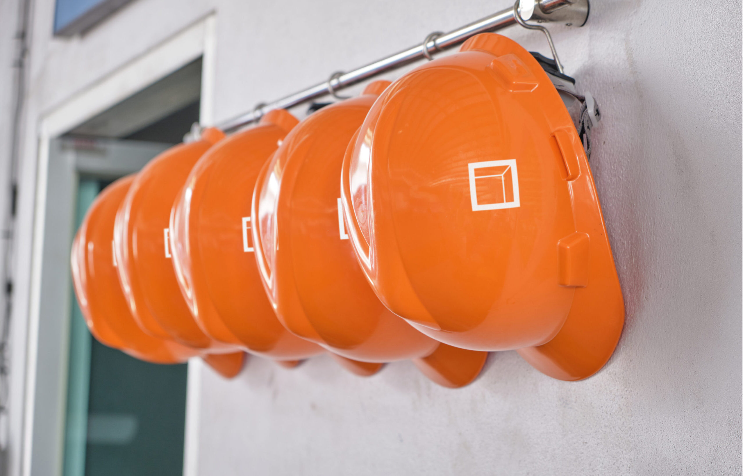 Rexford construction hard hats hanging on a wall